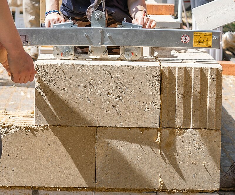 Verkleben großformatiger Lehmsteine mit Lehmdünnbettmörtel. Foto: © Conclay (Kimm GmbH & Co. KG)